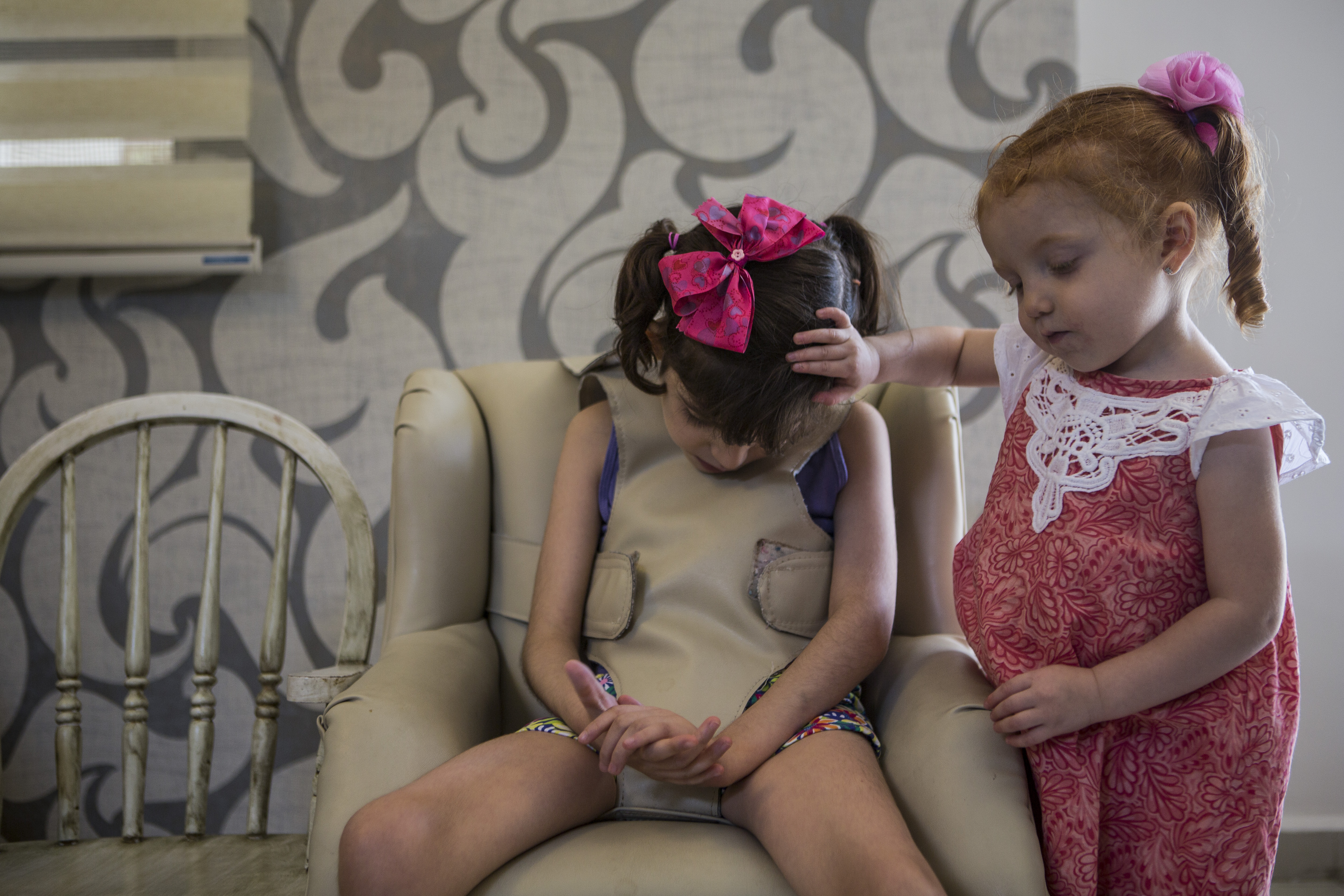 MONTERREY, MEXICO, AUGUST 12th, 2015: (L-R) Valentina, 2, conforts her sister Grace (Graciela Elizalde Benavides) as she goes through one of her hourly convulsions in the living room of their home in Monterrey, Mexico, on August 12, 2015 Graciela suffers from Lennox Gastaut Syndrome, a severe form of epilepsy. After trying everything they could, the family is now battling in justice to be able to give her Cannabadiol (or CBD), a marijuana based medicine. (Photo by Adriana Zehbrauskas for The Washington Post)