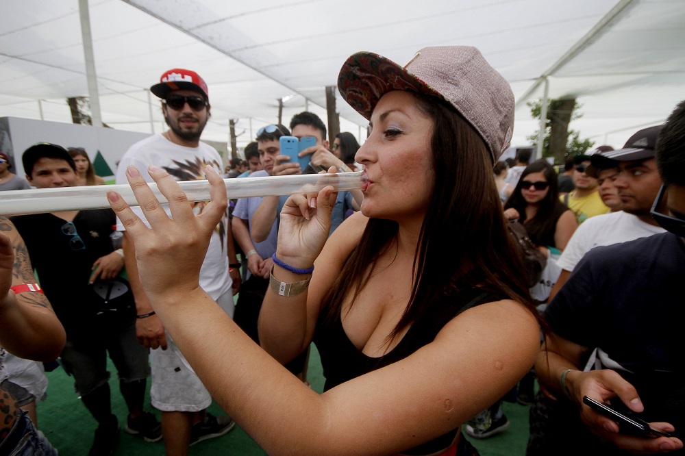 22 de Noviembre de 2014/SANTIAGO_. Una promotora fuma de una pipa durante el segundo dia de la Expoweed 2014, desarrollada en el Parque O Higgins, lugar donde mas de 100 expositores exiben diferentes productos de la cultura canabica_. FOTO: PEDRO CERDA/AGENCIAUNO_.